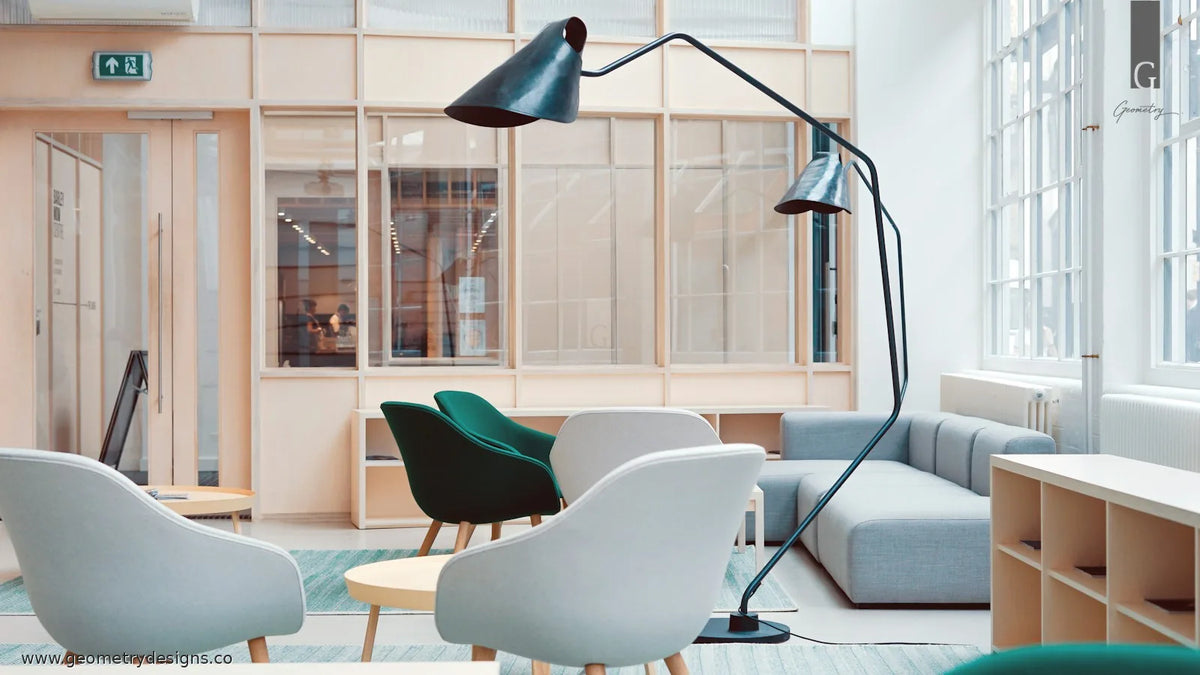 Bright modern lounge with soft seating and a glass-partitioned workspace beyond, showing a calm transition between living and work zones