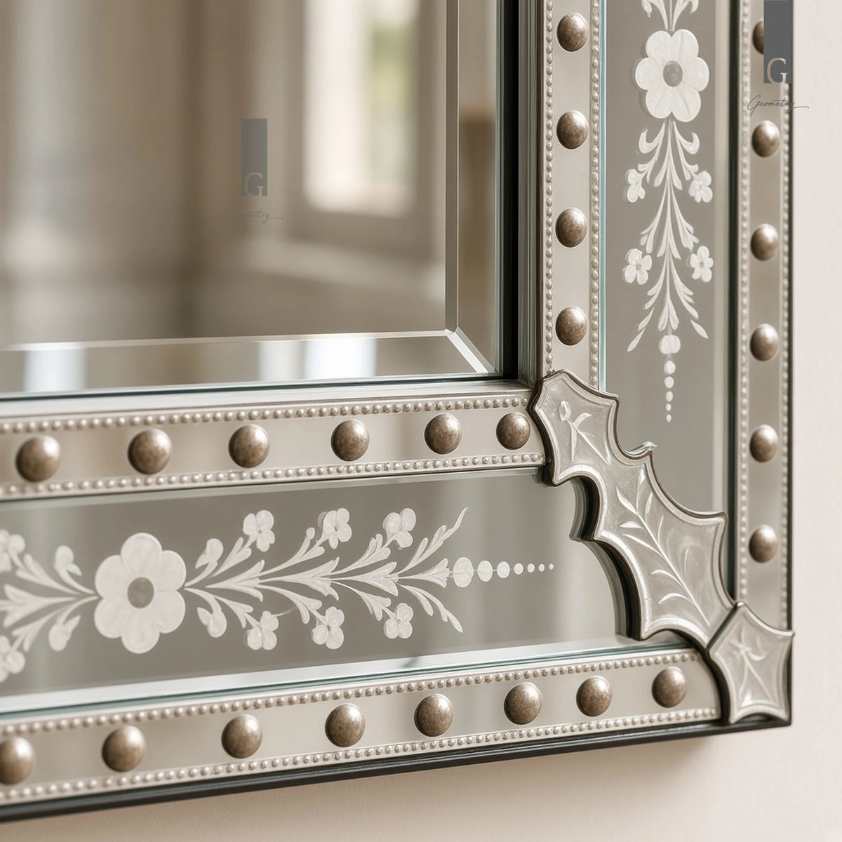 Geometry Designs Venetian Mirror lower corner join with glass leaf ornament and studded bands, shown in a close-up.
